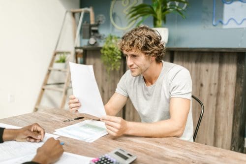 A Little Rock homeowner reviewing policy documents before changing home insurance providers.