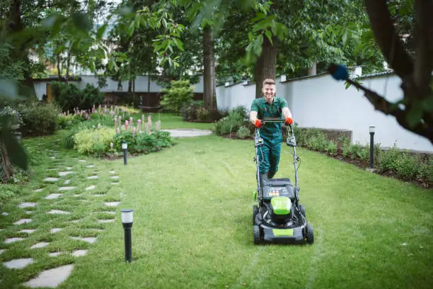 A man mowing the lawn for a lawn care business in Arkansas