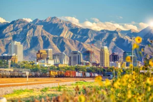 A train going down the tracks with Utah City in the background.