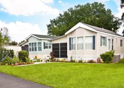a manufactured home with a lawn and a driveway