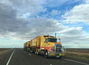 a yellow and red hotshot truck on a road