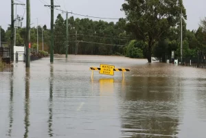 a flooded road with a yellow sign